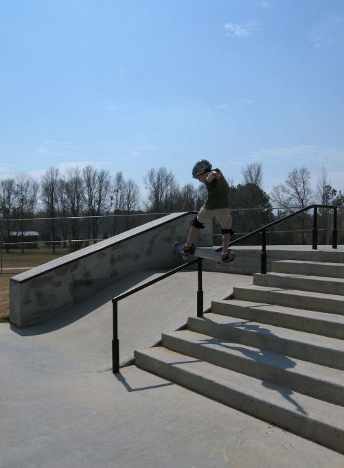 Chris Coffman styles a frontside board slide down the 8-stair rail